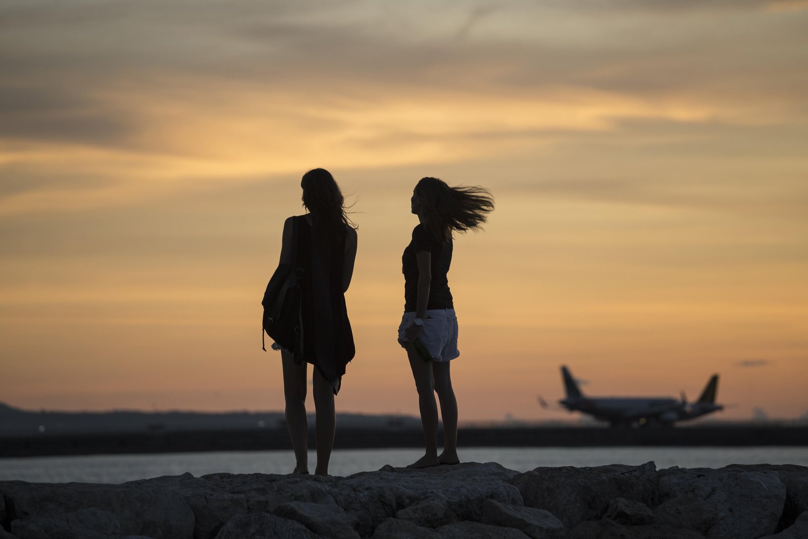 indonesia-bali-two-women-watching-the-sunset-ove-2024-09-18-19-53-03-utc