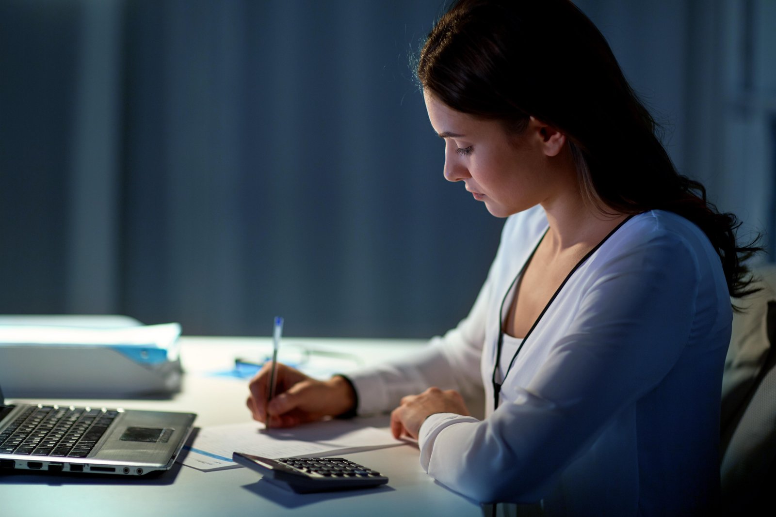 woman-with-calculator-and-papers-at-night-office-2024-09-27-17-29-36-utc