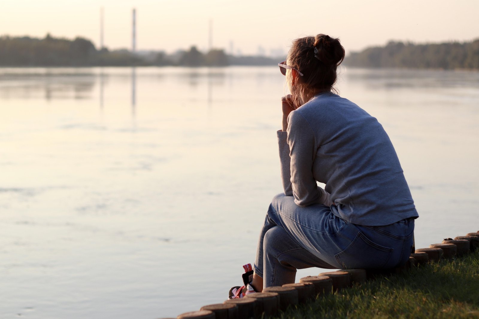 young-woman-is-sitting-by-the-river-bank-and-think-2025-03-08-08-39-18-utc